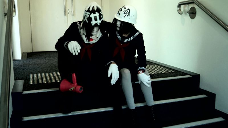 Shimizu grabbing onto Toda's helmet.